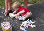 Joey watches his Mommy spell his name in sidewalk chalk.