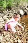 The St. Croix is FINALLY (and barely) warm enough to swim in.  Unfortunately, the water is still much to high to expose sand.  So, Sammi makes due with her new sand toys on the rock beds.