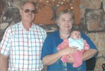 Oma, Opa, and Samantha in front of the fireplace at home.