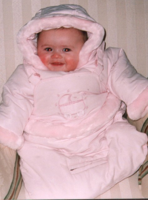 Sammi grins with rosy cheeks in the bunting that Oma gave her.