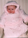 Sammi grins with rosy cheeks in the bunting that Oma gave her.